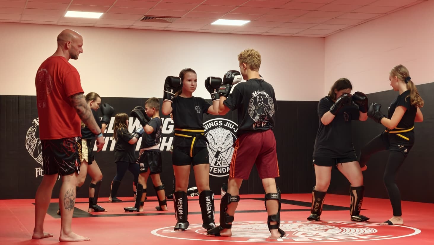 Hellwings Fit&Fight – Trainer mit Kindern beim Partnertraining im Thaiboxkurs für Kinder