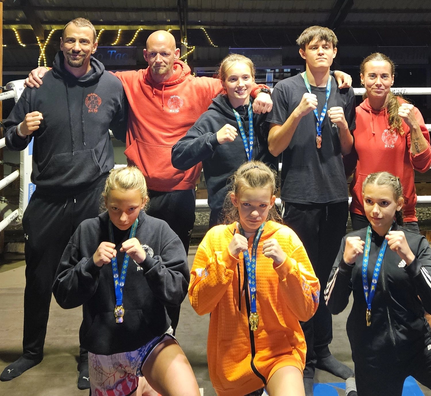 Hellwings Fit&Fight – Trainerteam und Kinder mit Medaillen vor dem Ring